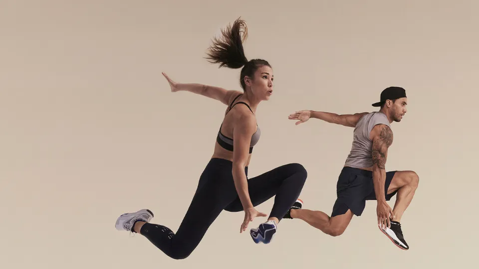 Two people in athletic wear captured mid-air in dynamic action poses