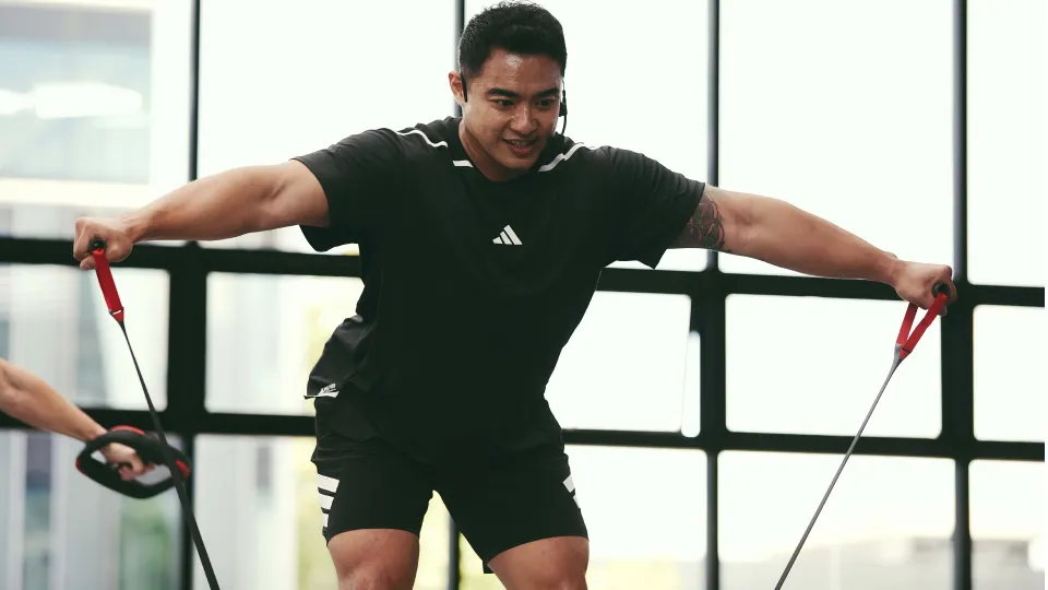 A person performs a resistance band exercise indoors
