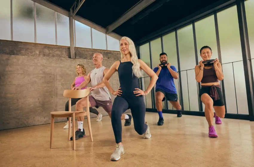 Participants in a group exercise class with smart tech doing Les Mills THRIVE